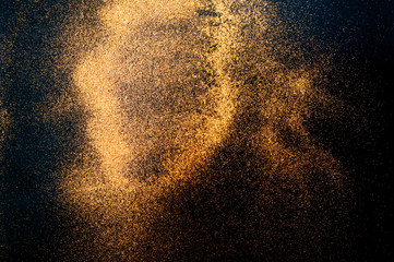 Fototapeta na wymiar Black background with golden sparkles. Blurred effect. 