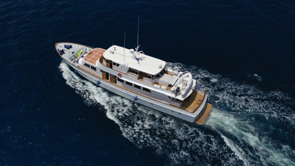Aerial drone photo of luxury yacht cruising deep blue sea in Mediterranean Aegean island destination located in Greece