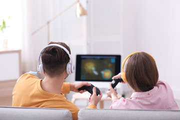 Young couple playing video games at home
