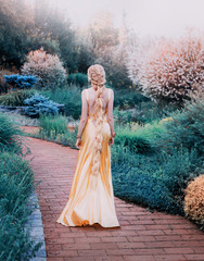 mysterious lady in chic yellow expensive luxury dress in magnificent garden, mysterious princess...