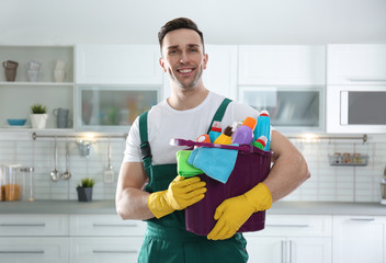 Portrait of janitor with bucket of detergents in kitchen. Cleaning service
