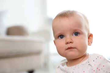 Portrait of cute baby girl in room. Space for text
