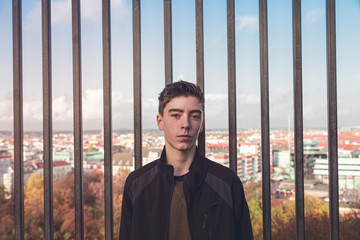 portrait of a smiling young man in front of bars and Berlin