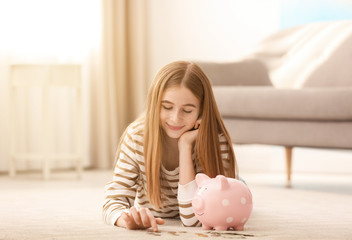 Obraz na płótnie Canvas Teen girl with piggy bank and money at home