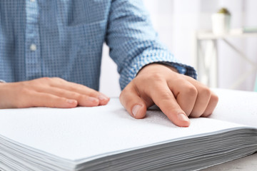 Blind person reading book written in Braille, closeup