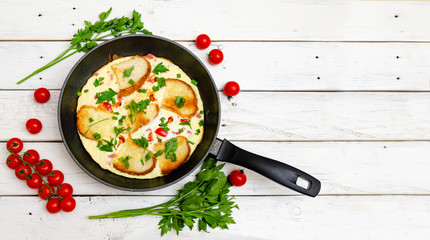 Rustic omelette breakfast with tomatoes and parsley on white rustical background