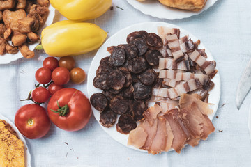 Homemade sausages, bacon, tomato and pepper served on a plate