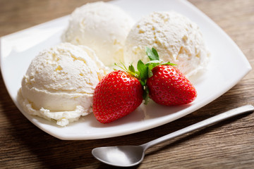 plate of ice cream scoops with fresh strawberry