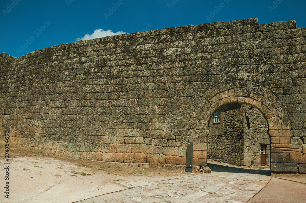 Wall mural Open gate on a stone outer wall