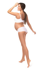 Young and beautiful pregnant woman on white background