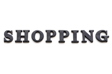 The inscription SHOPPING. SHOPPING in black bulk letters on a white background. Photo of the lettering, close-up