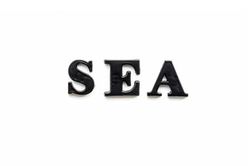 The inscription SEA. SEA in black bulk letters on a white background. Photo of the lettering, close-up