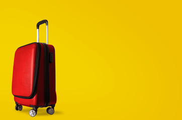 Red suitcase on yellow wall, holiday background