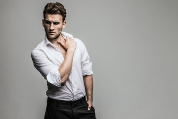 Obraz premium Portrait of young and handsome model in a white shirt. Studio shot. Copy space.
