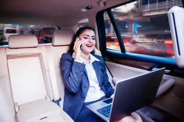 Businesswoman works with laptop in car