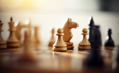 Wooden chess pieces on the chessboard.