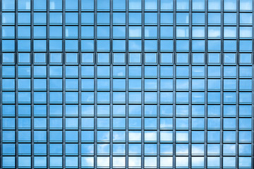 Blue sky and clouds reflecting in windows of modern office building