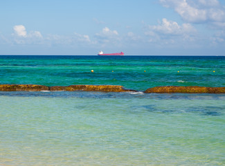 Beautiful turquoise sea with a cargo ship in the distance.