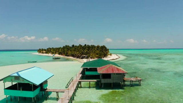 Tropical landscape: small island with beautiful beach, palm trees by turquoise water view from above. Onok Island, Balabac, Philippines. Summer and travel vacation concept