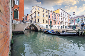 Fototapeta na wymiar Green water canal with the bridge of Venice