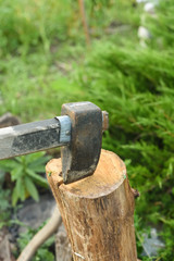 The process of cutting wood with a cleaver. Axe in the log