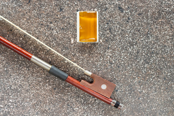 violin bow and rosin isolated on a concrete background.