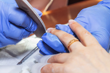 April 28, 2019 Minsk Belarus Manicurist processes nails with a scraper for manicure at home