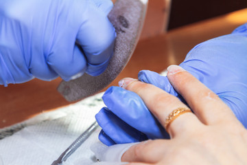 April 28, 2019 Minsk Belarus Manicurist processes nails with a scraper for manicure at home