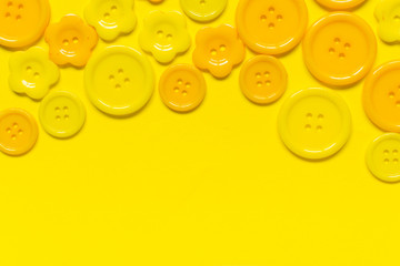 Fototapeta premium Various yellow sewing buttons on yellow background