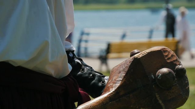 cossack toss up a big heavy wooden mace in hands outdoors on the summer retro festival, Close up