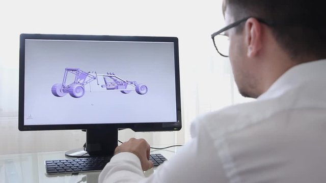 Engineer, Constructor, Designer, Architect in Glasses Working on a Personal Computer. He Creating New Component of BAGGI in CAD Program. Freelance Work