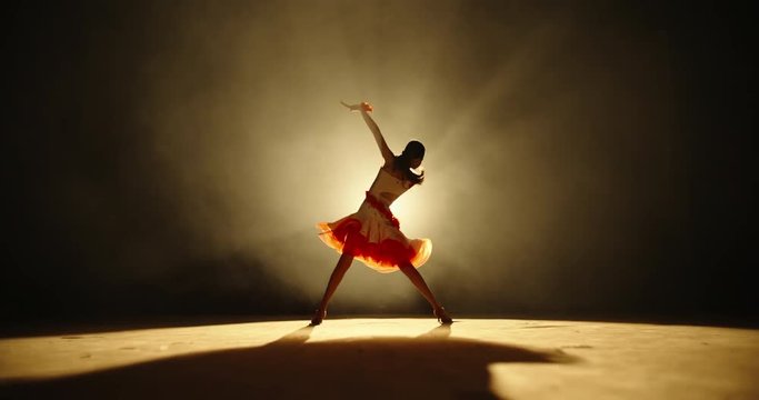 Talented asian female teenager is performing ballroom sport dance on stage with smoked black background - childhood dream, childhood memories concept slow motion 4k footage