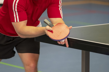 Table tennis player serving, close-up