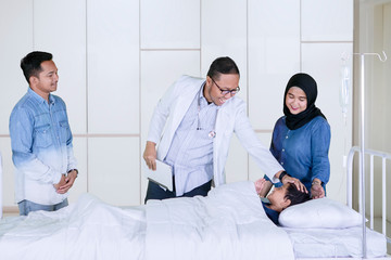 Pediatrician checking his patient in the hospital