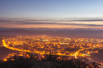 Fototapeta na wymiar Stunning late blue hour view of Pirot cityscape with hot city lights and colorful sky