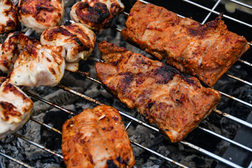 Juicy Pork steak, ribs and chicken meat on bbq grill, homemade barbecue, closeup.