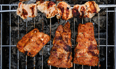 Juicy Pork steak, ribs and chicken meat on bbq grill, homemade barbecue, closeup.