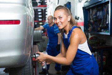 female mechanic working on car tyre service