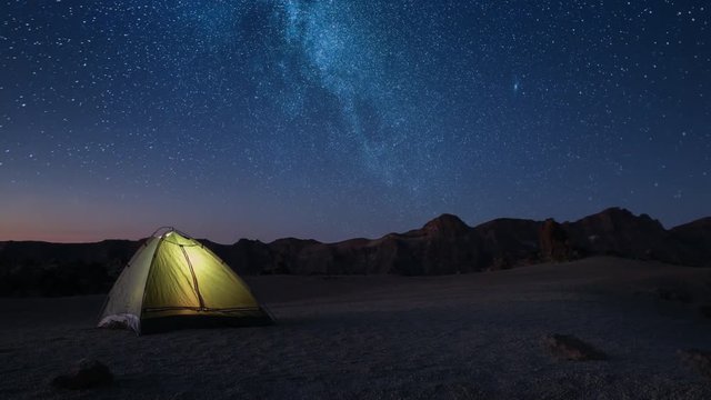 Adventure romance night time and meeting dawn in a tourist tent on a starry night high in the mountains before dawn