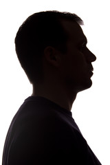 Portrait of a young man, side view - dark isolated silhouette