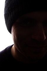 Portrait young man, unshaven, side view in cap - dark silhouette