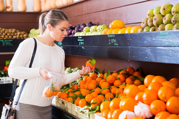 Girl choosing fruits in grocery