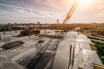 Roof of construction site of new multi-storey residential building, industrial construction crane...