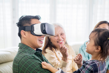 Young man wearing VR headset with his family