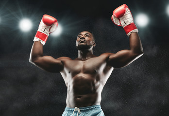 African boxer raising his arms in winner gesture
