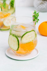Cold drink with cucumber and citrus at white background