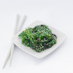 Isolated chinese food on a white background. Food is placed in the pot. Nearby lie chopsticks.