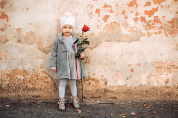 This is first love. small kid with red rose. happy childhood. retro fashion. happy birthday. wedding. little girl in vintage coat. Beauty. love present. childrens day. valentines day. romantic date