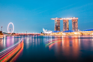Fototapeta premium SINGAPORE, SINGAPORE - MARCH 2019: Skyline of Singapore Marina Bay at night with Marina Bay sands, Art Science museum and tourist boats