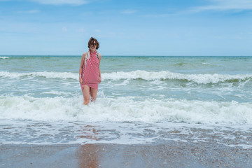 Attractive middle-aged woman walks on the water in the sea, ocean.